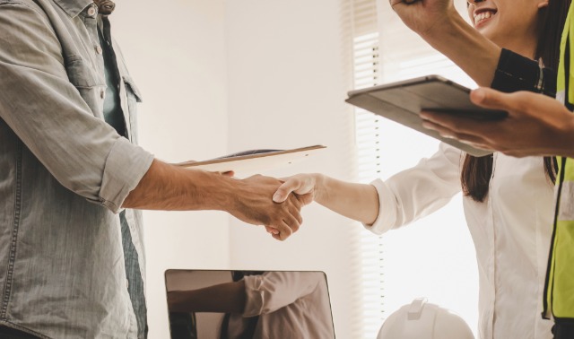 Close up handshake between a contractor and clients.
