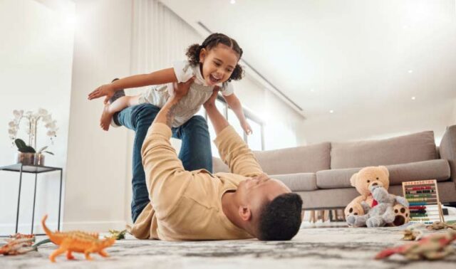 Happy father and daughter playing together at home.