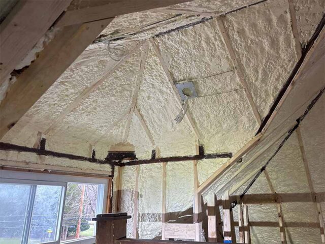 Closed cell spray foam insulation installed along attic roofline and wall cavities in residential home by Foam InSEALators.