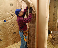 Worker installing a wall fiberglass